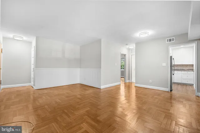 a view of an empty room with wooden cabinet