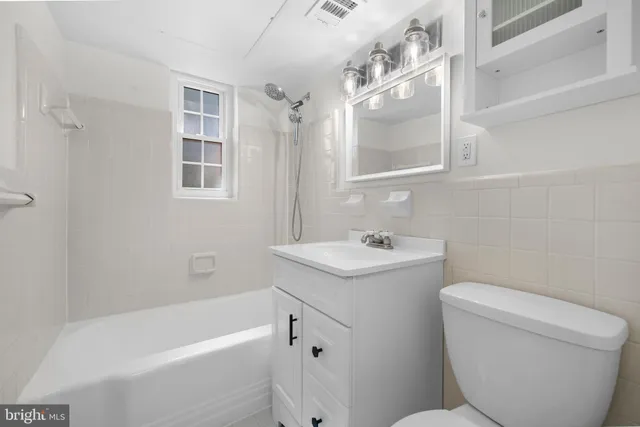 a bathroom with a sink toilet vanity and bathtub
