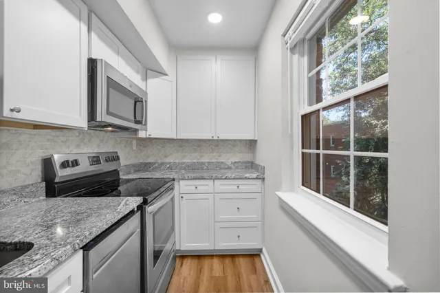a kitchen with granite countertop a stove a sink and a granite counter tops