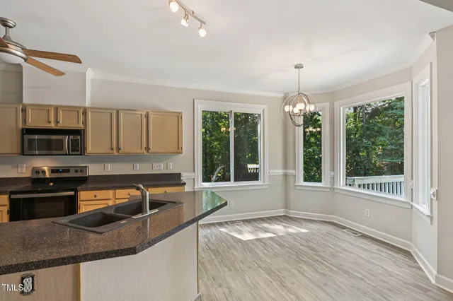 a kitchen with stainless steel appliances granite countertop a sink a stove and a granite counter tops with wooden floors