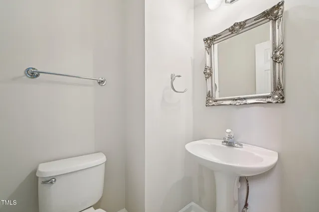 a bathroom with a sink a toilet and mirror