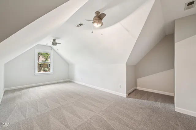 an empty room with windows and ceiling fan