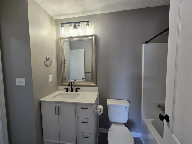 a bathroom with a toilet sink and mirror