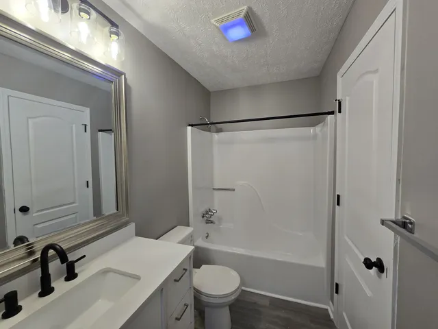 a bathroom with a sink a toilet and a large mirror