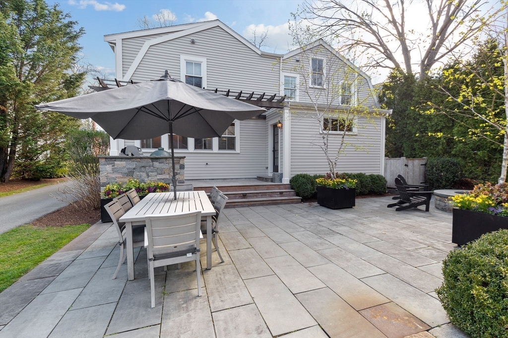 132 Main Street Hingham, MA 02043 - Photo 33 of 42 a backyard of a house with table and chairs under an umbrella