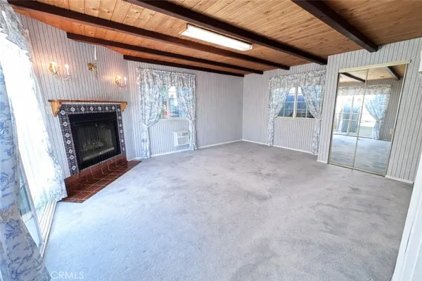 a view of empty room with wooden floor and fireplace