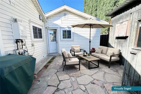 a backyard of a house with barbeque oven table and chairs