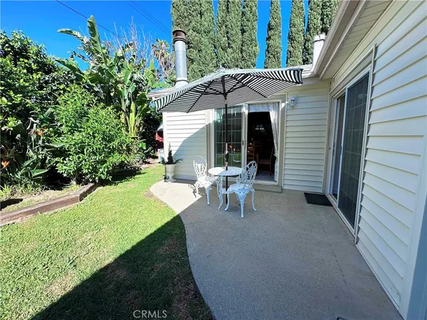 a view of a patio with table and chairs under an umbrella