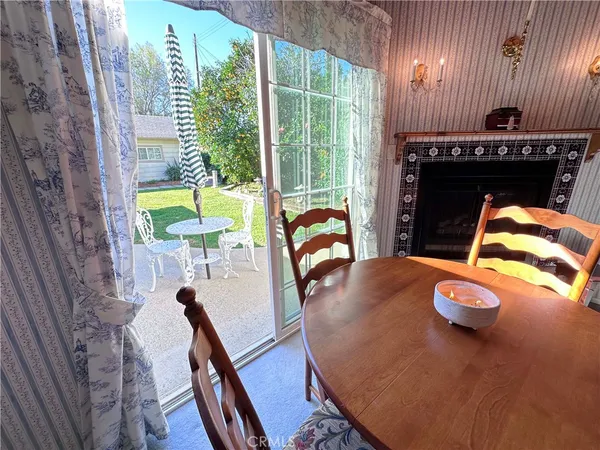 a view of a dining room with furniture a fireplace and wooden floor