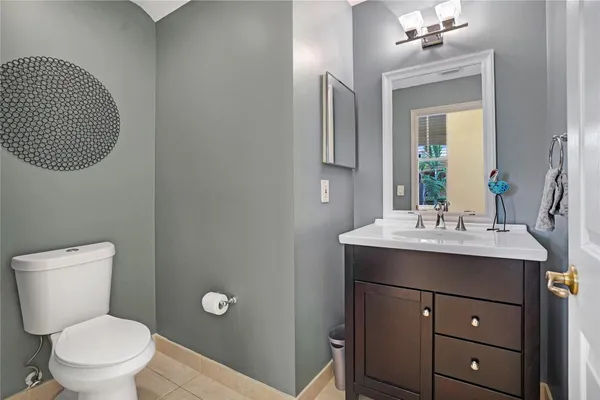 a bathroom with a toilet a sink and mirror