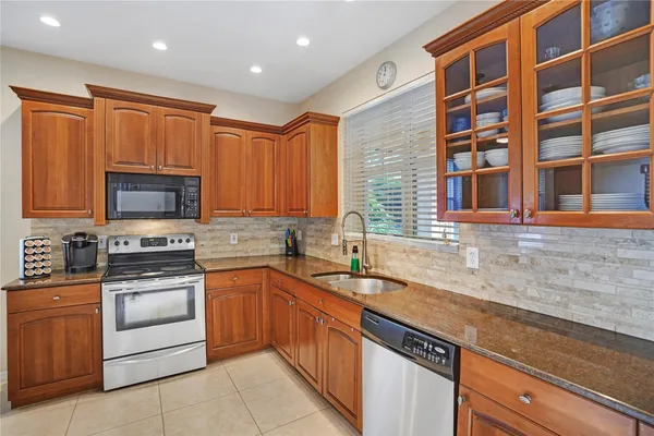 a kitchen with stainless steel appliances granite countertop a sink and a stove