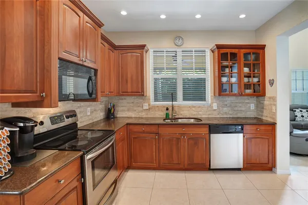 a kitchen with stainless steel appliances granite countertop a stove sink and cabinets