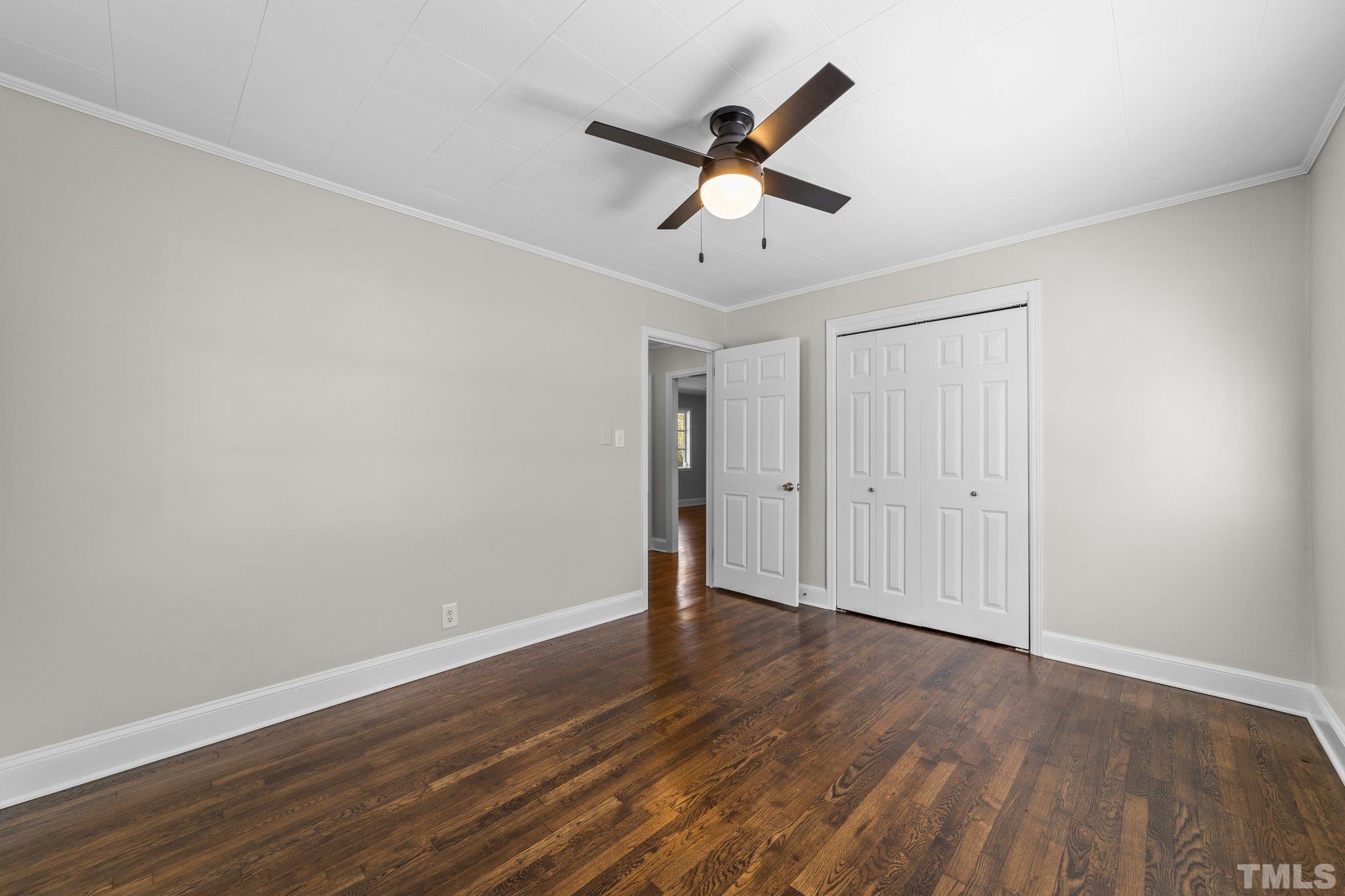 908 Goodwin Road Durham, NC 27712 - Photo 11 of 22 an empty room with wooden floor fan and windows