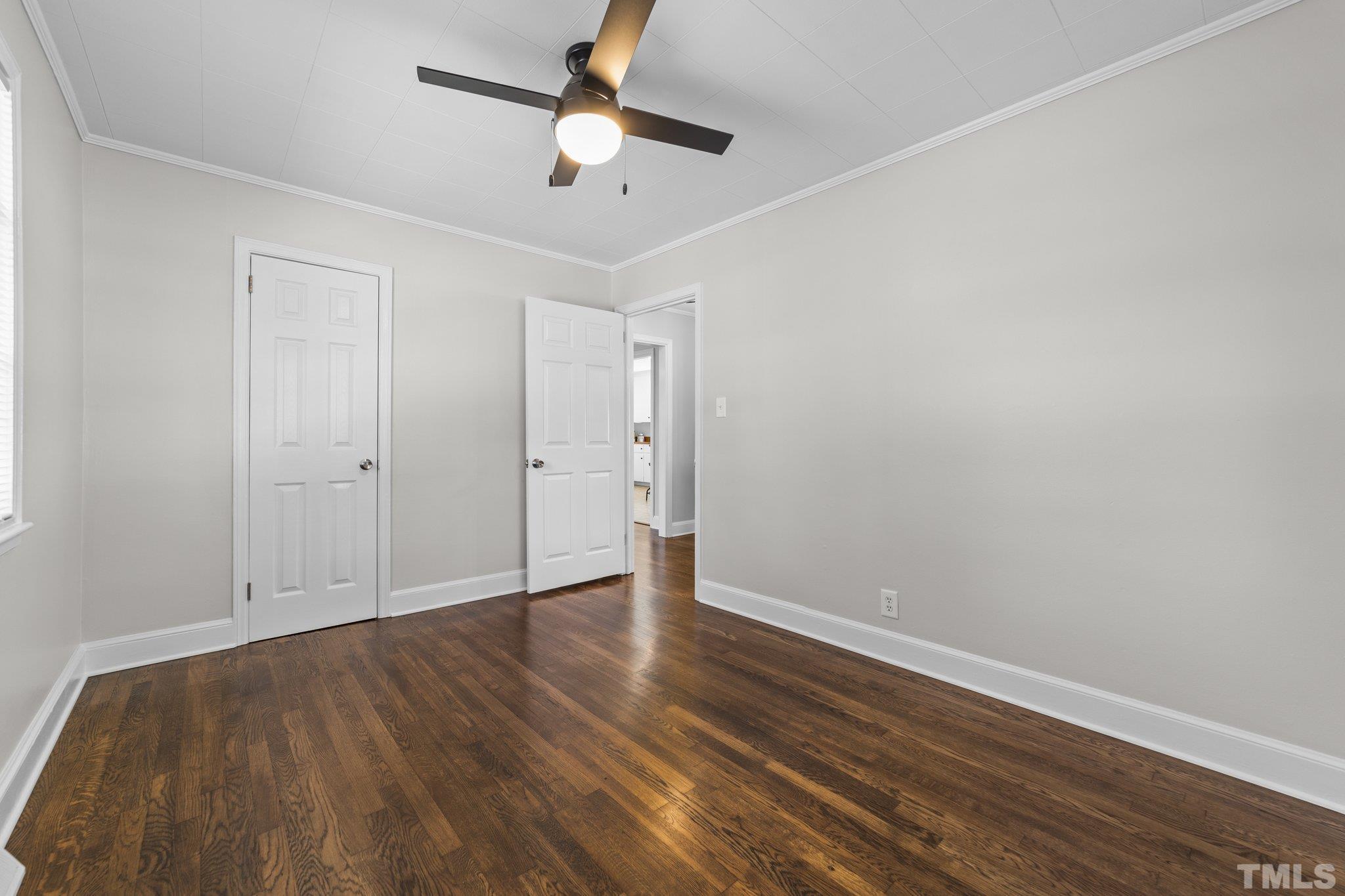 908 Goodwin Road Durham, NC 27712 - Photo 16 of 22 an empty room with wooden floor and ceiling fan