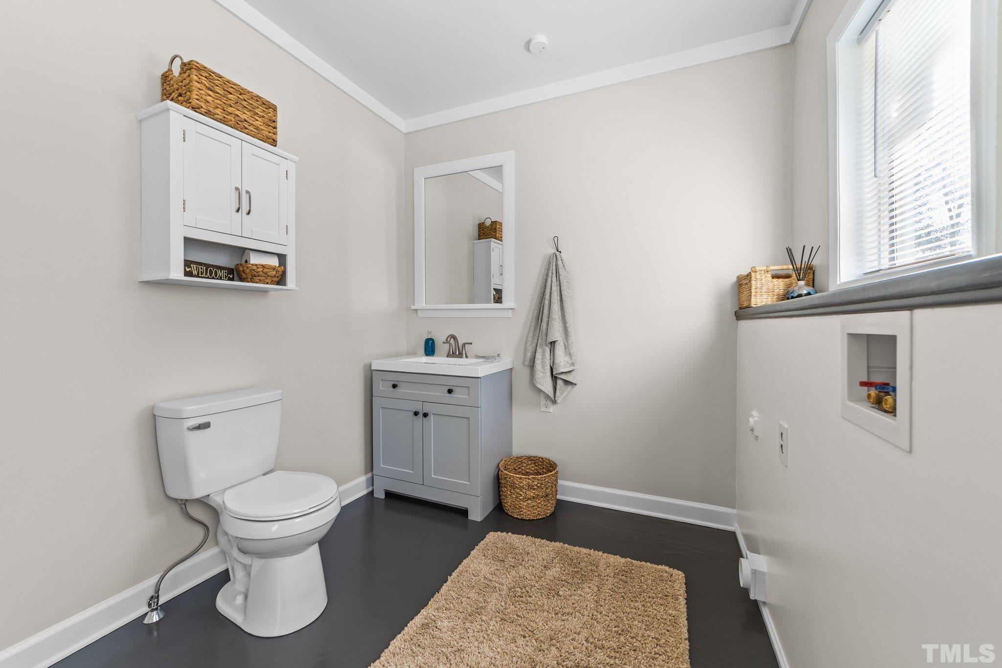 908 Goodwin Road Durham, NC 27712 - Photo 20 of 22 a bathroom with a toilet a sink and a window
