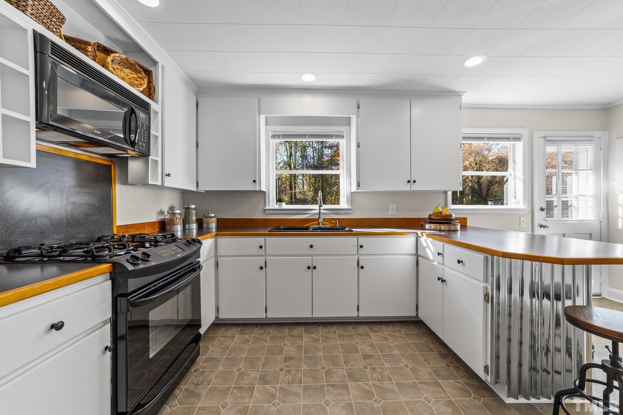 908 Goodwin Road Durham, NC 27712 - Photo 9 of 22 a kitchen with a sink stove and cabinets