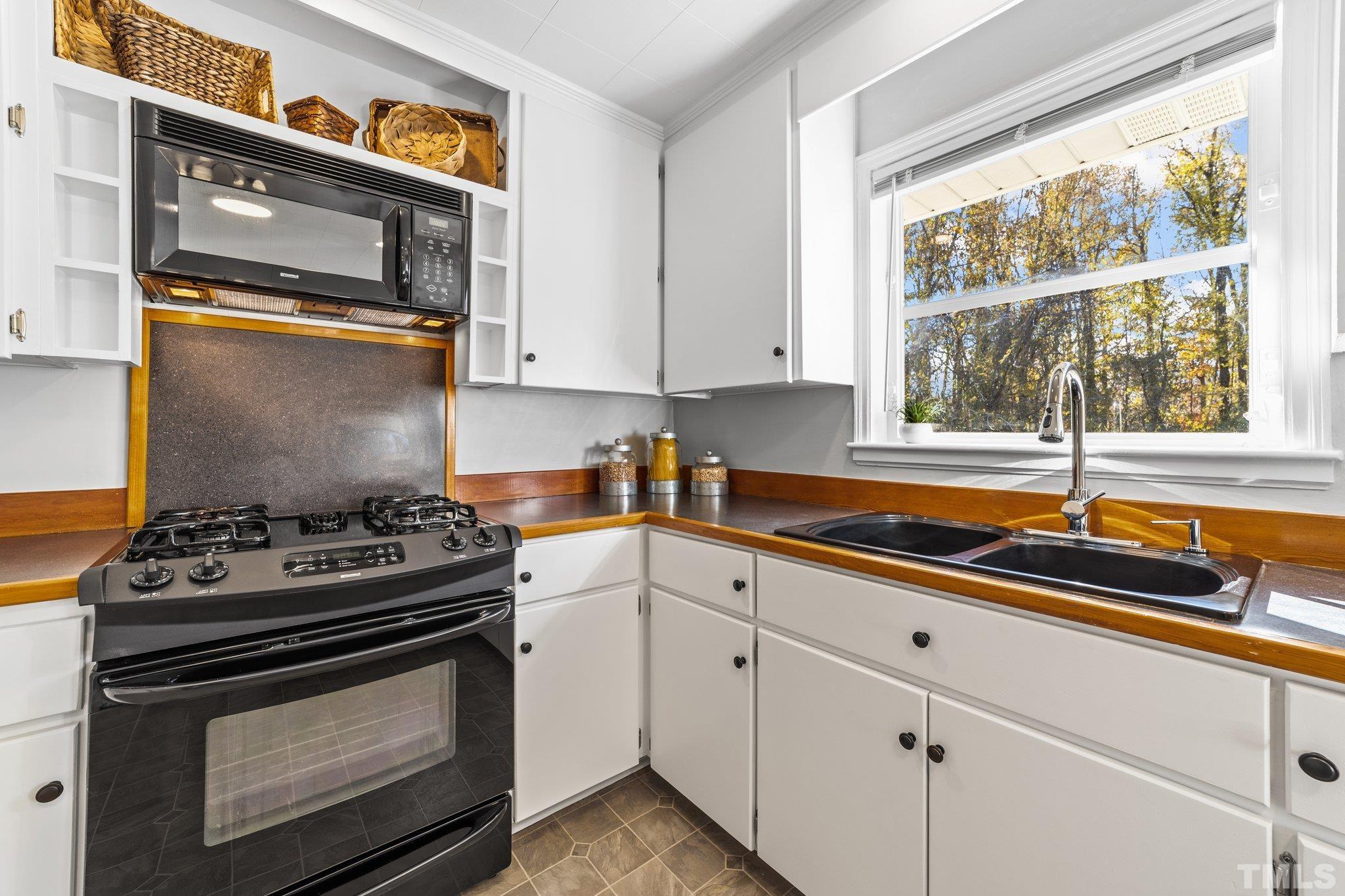 908 Goodwin Road Durham, NC 27712 - Photo 10 of 22 a kitchen with stainless steel appliances a stove a sink and a window