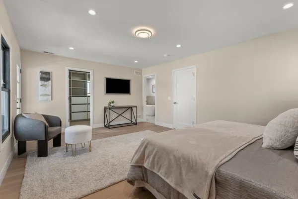 a spacious bedroom with a bed and a chair