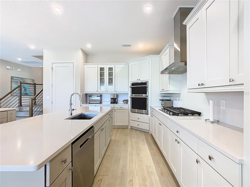 7948 Jacks Clb Drive Reunion, FL 34747 - Photo 17 of 85 a large kitchen with stainless steel appliances a sink a stove and cabinets