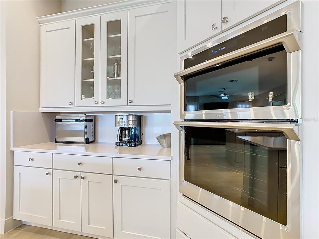 7948 Jacks Clb Drive Reunion, FL 34747 - Photo 19 of 85 a kitchen with granite countertop white cabinets and white appliances