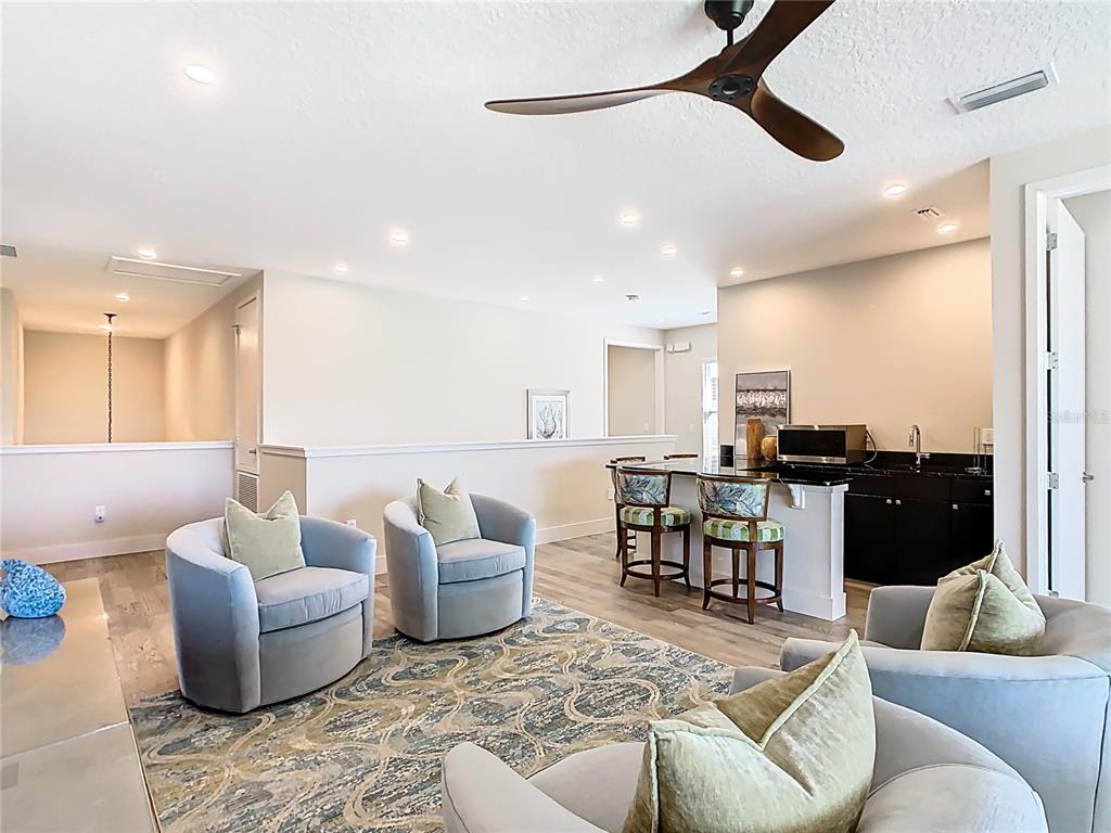 7948 Jacks Clb Drive Reunion, FL 34747 - Photo 37 of 85 a living room with furniture kitchen view and a chandelier