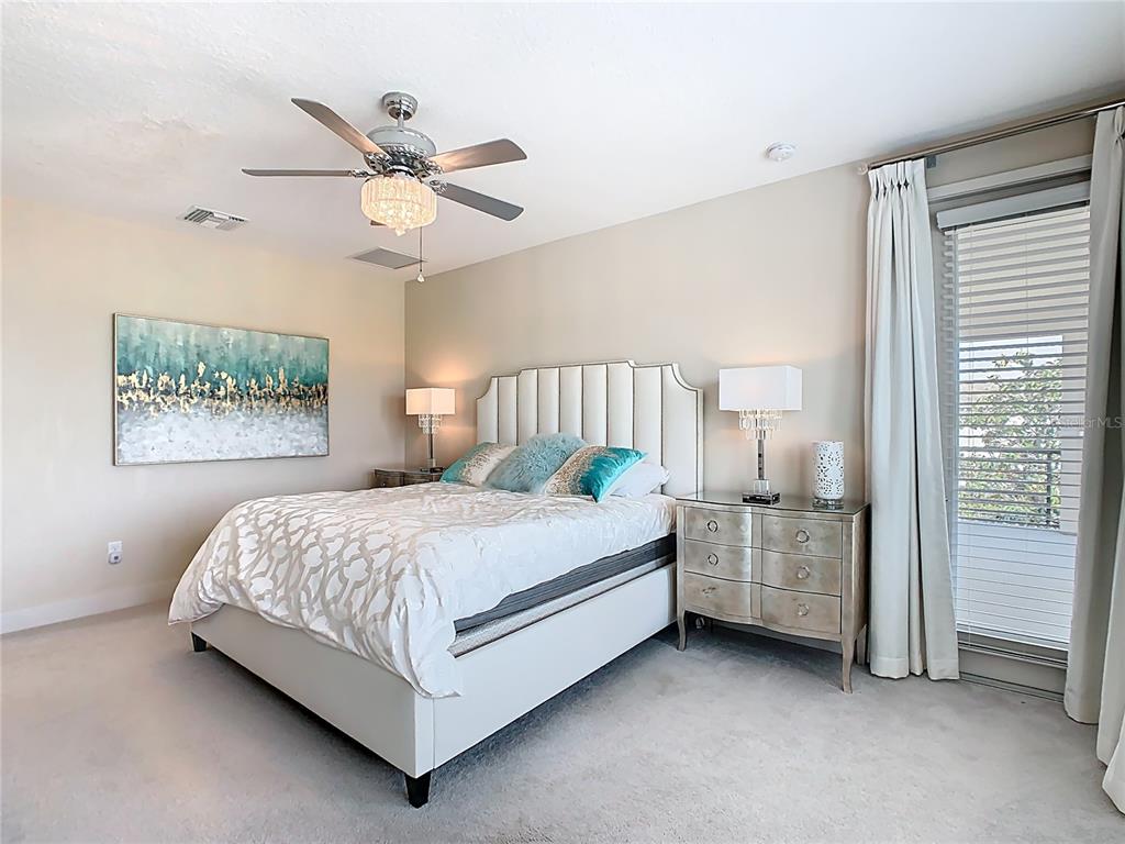 7948 Jacks Clb Drive Reunion, FL 34747 - Photo 39 of 85 a bedroom with a bed and a chandelier