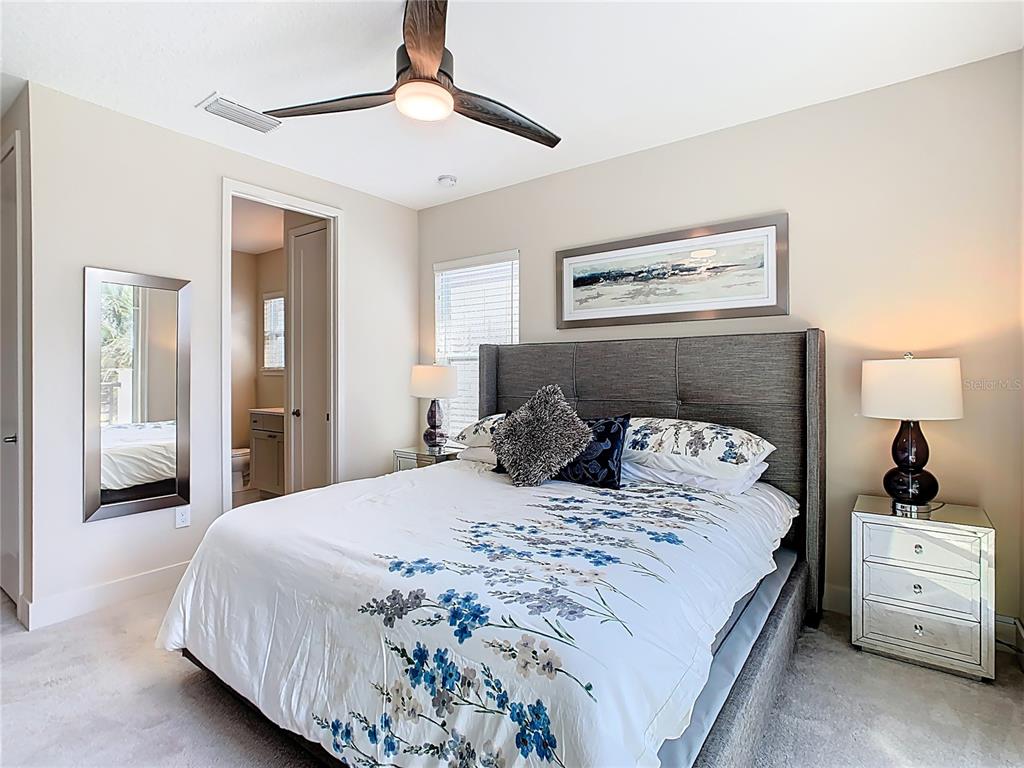 7948 Jacks Clb Drive Reunion, FL 34747 - Photo 46 of 85 a bedroom with a large bed and a chandelier