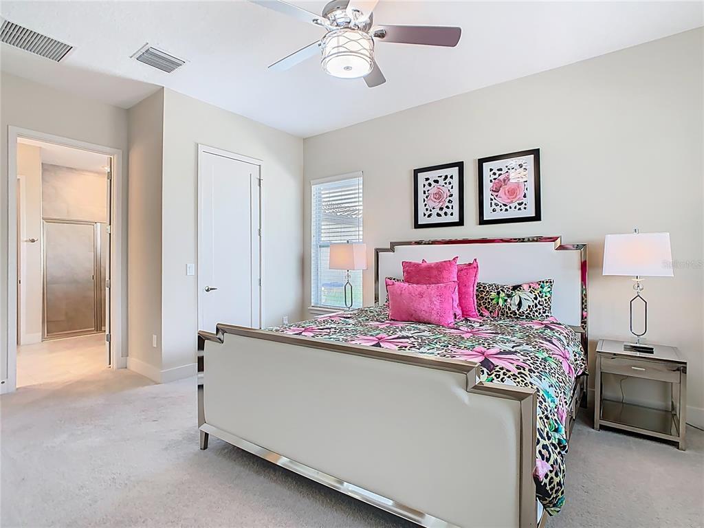 7948 Jacks Clb Drive Reunion, FL 34747 - Photo 51 of 85 a bedroom with a bed and a chandelier