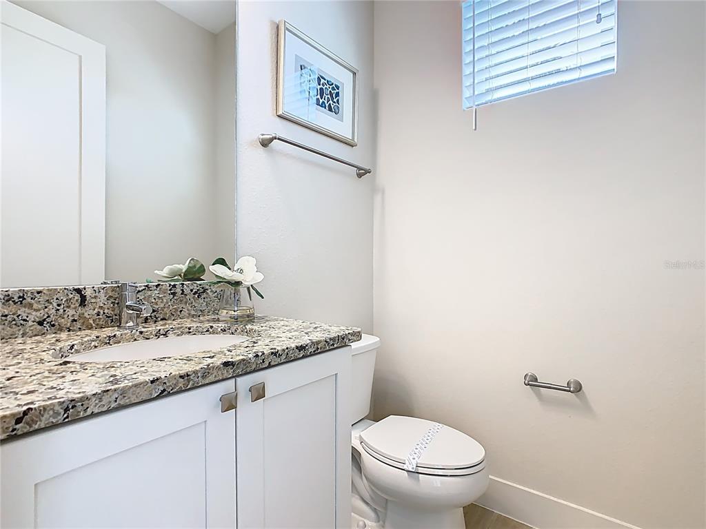 7948 Jacks Clb Drive Reunion, FL 34747 - Photo 53 of 85 a bathroom with a granite countertop sink and a toilet