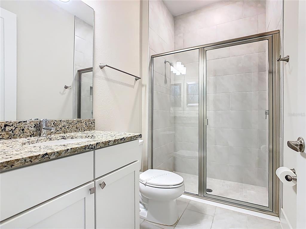 7948 Jacks Clb Drive Reunion, FL 34747 - Photo 59 of 85 a bathroom with a granite countertop sink toilet and shower