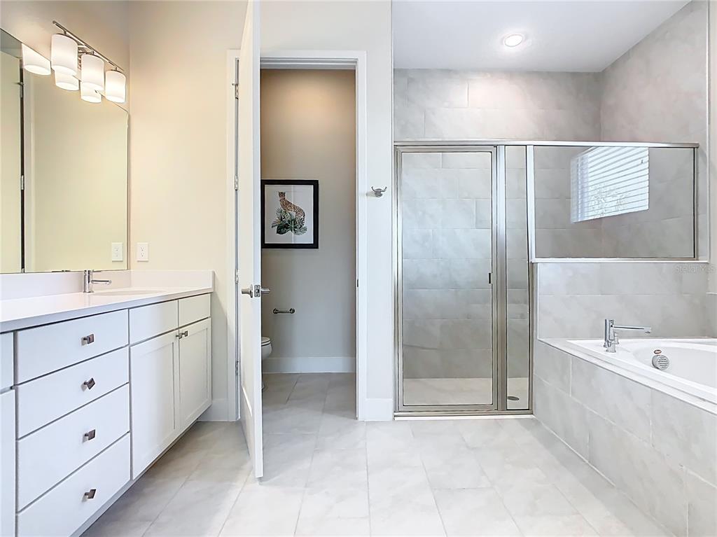 7948 Jacks Clb Drive Reunion, FL 34747 - Photo 65 of 85 a spacious bathroom with a double vanity sink a large mirror and a bathtub