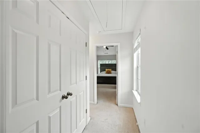 a view of a hallway with a livingroom and a bathroom