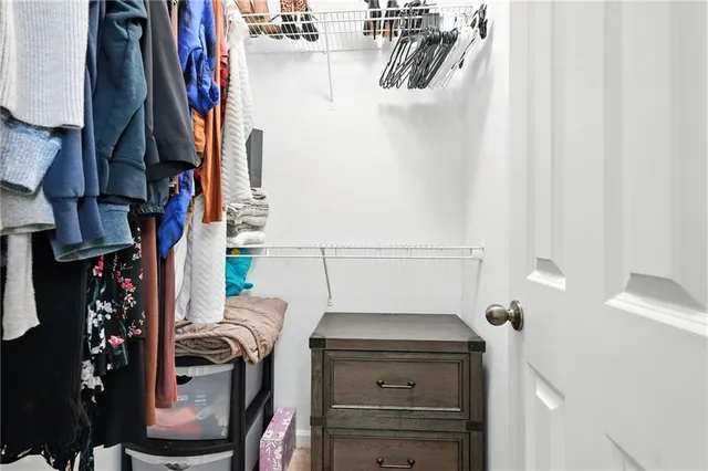 a view of walk in closet with clothes and shoes