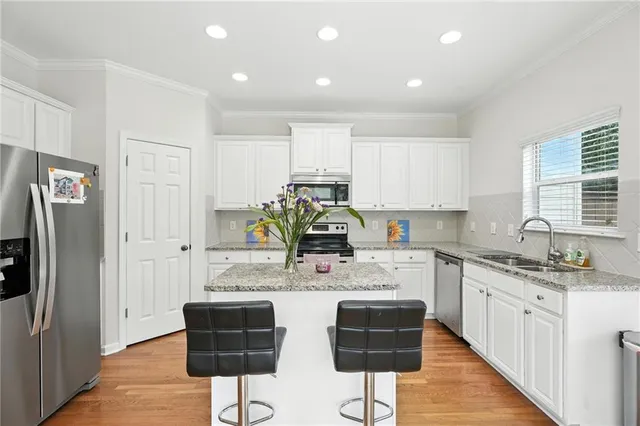 a kitchen with stainless steel appliances granite countertop a refrigerator and a stove top oven