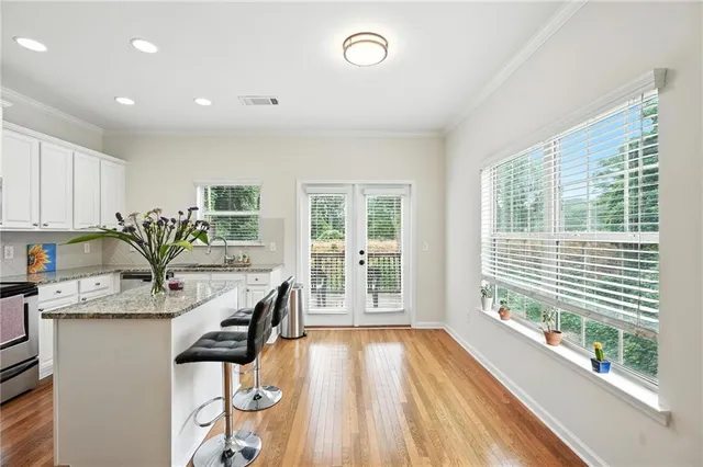 a view of a kitchen with kitchen island a large window a sink and stainless steel appliances