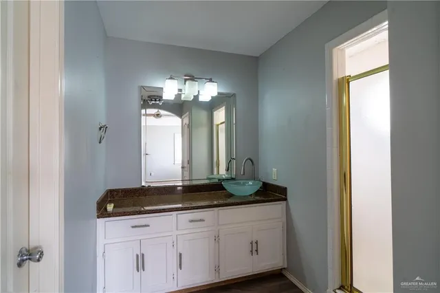 a bathroom with a granite countertop sink and a mirror