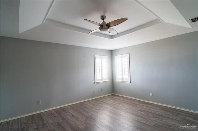 a view of a room with window ceiling fan and hardwood floor