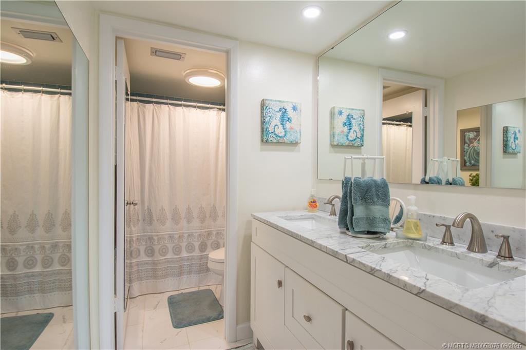 1866 Southwest Palm City Road, Unit 101 Stuart, FL 34994 - Photo 17 of 23 a bathroom with a granite countertop sink and a mirror
