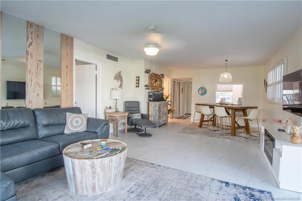 1866 Southwest Palm City Road, Unit 101 Stuart, FL 34994 - Photo 22 of 23 a living room with furniture and a dining table with kitchen view