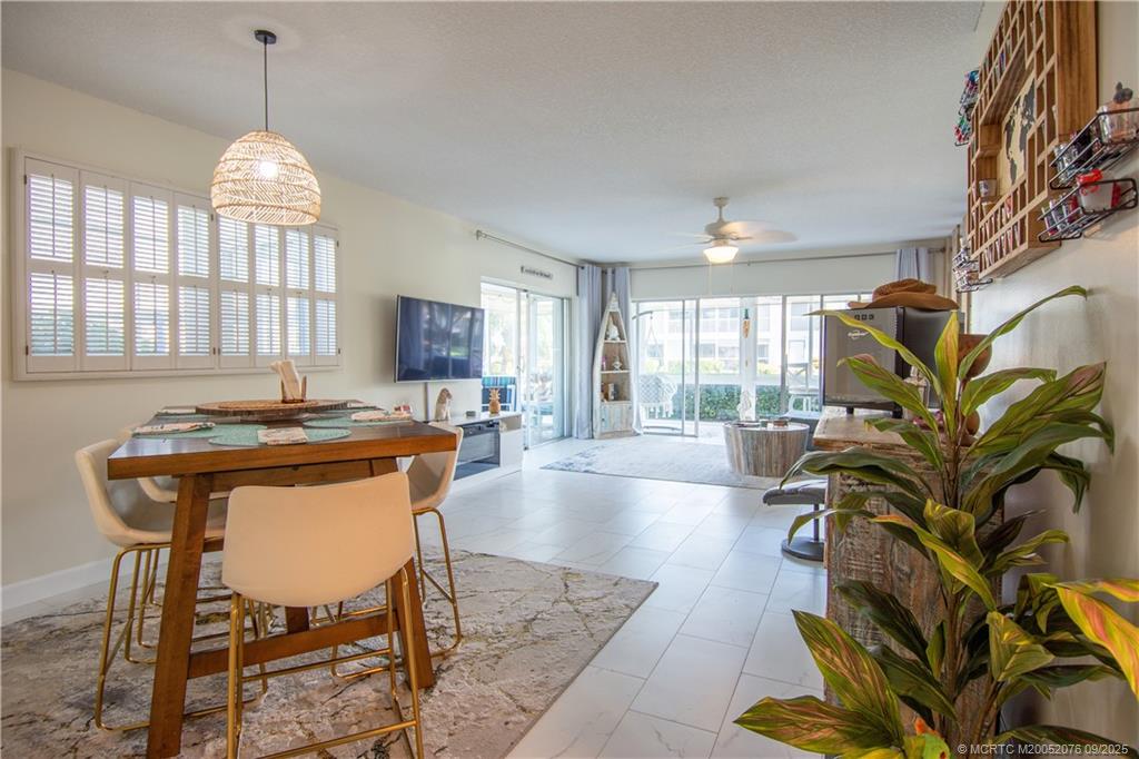1866 Southwest Palm City Road, Unit 101 Stuart, FL 34994 - Photo 3 of 23 a very nice looking room with a large window a dining table and a chandelier