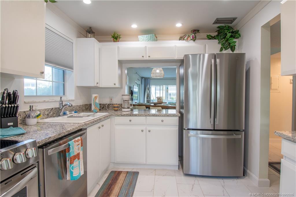 1866 Southwest Palm City Road, Unit 101 Stuart, FL 34994 - Photo 5 of 23 a kitchen with a refrigerator a sink and a stove top oven