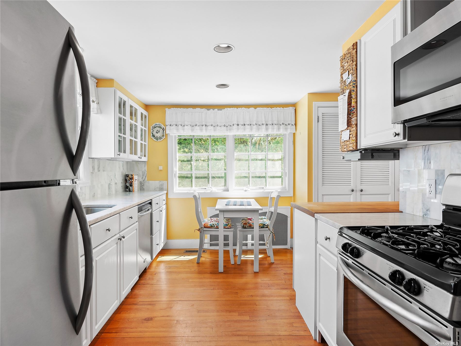 41 East Hampton, undefined 00000 - Photo 4 of 14 a kitchen with stainless steel appliances granite countertop a stove top oven a sink a dining table and chairs with wooden floor