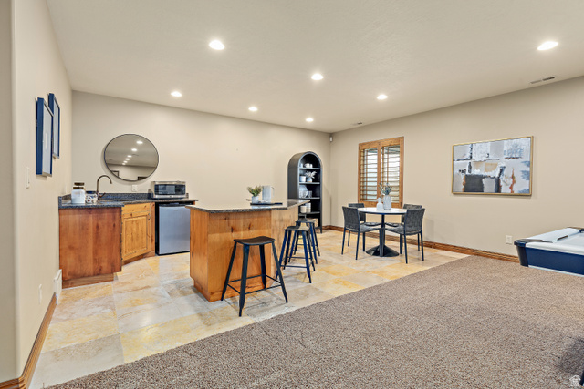 552 East Johns Way Sandy, UT 84070 - Photo 46 of 67 Recessed lighting illumination, wood-finish cabinetry, stone flooring, and a countertop with an integrated sink