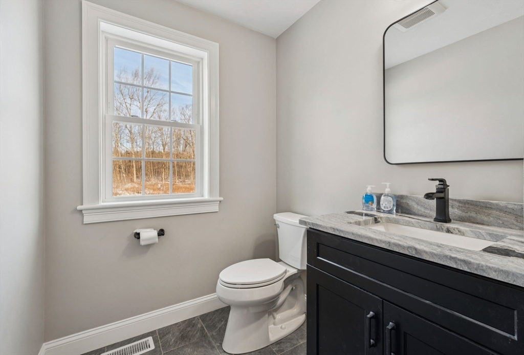 140 Ridge Road Rutland, MA 01543 - Photo 16 of 39 a bathroom with a granite countertop sink toilet a mirror and a window