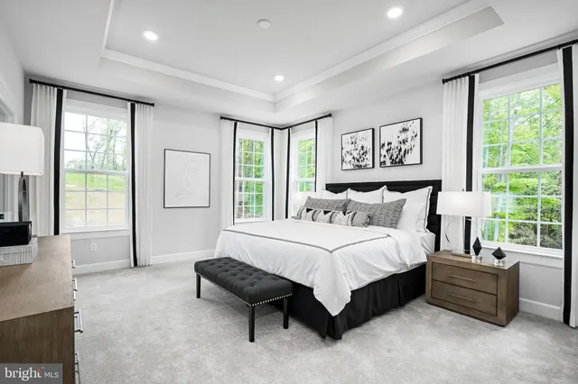 a spacious bedroom with a bed a couch and a large window