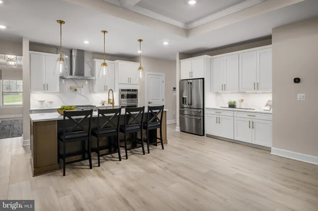 a kitchen with stainless steel appliances kitchen island granite countertop a table chairs sink and cabinets