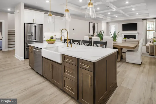 a large kitchen with lots of counter space a sink appliances and living room view