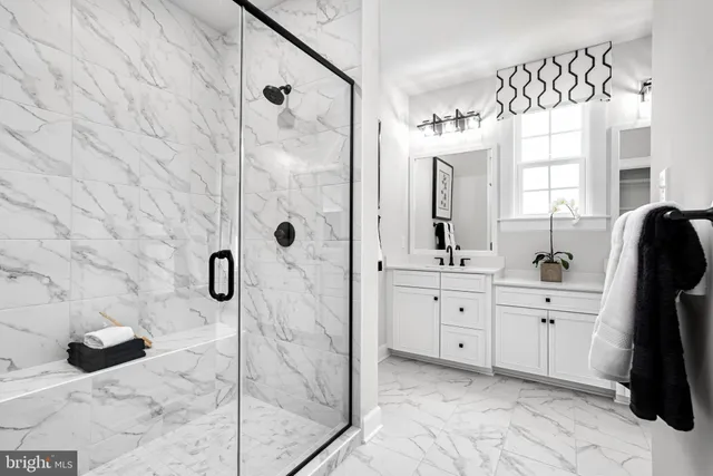 a spacious bathroom with a double vanity sink a mirror a glass door a shower and vanity