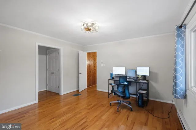 a view of a workspace with furniture and wooden floor