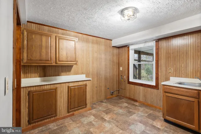 a kitchen with a stove a sink and cabinets